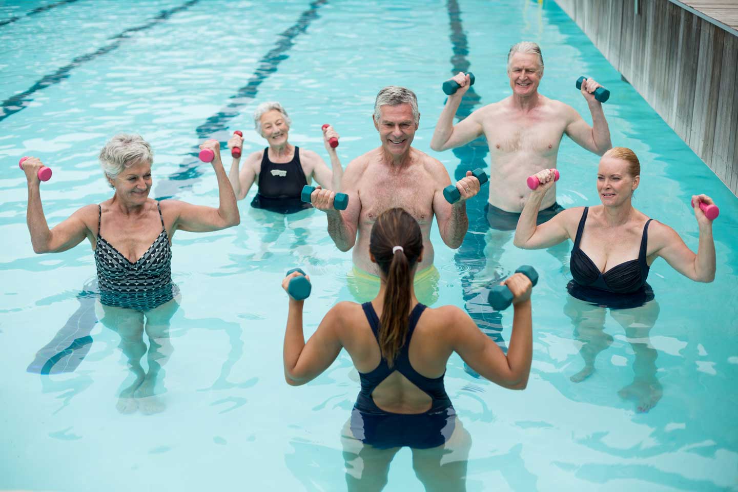 Hidroterapia: exercícios com halteres flutuantes em piscina de água aquecida