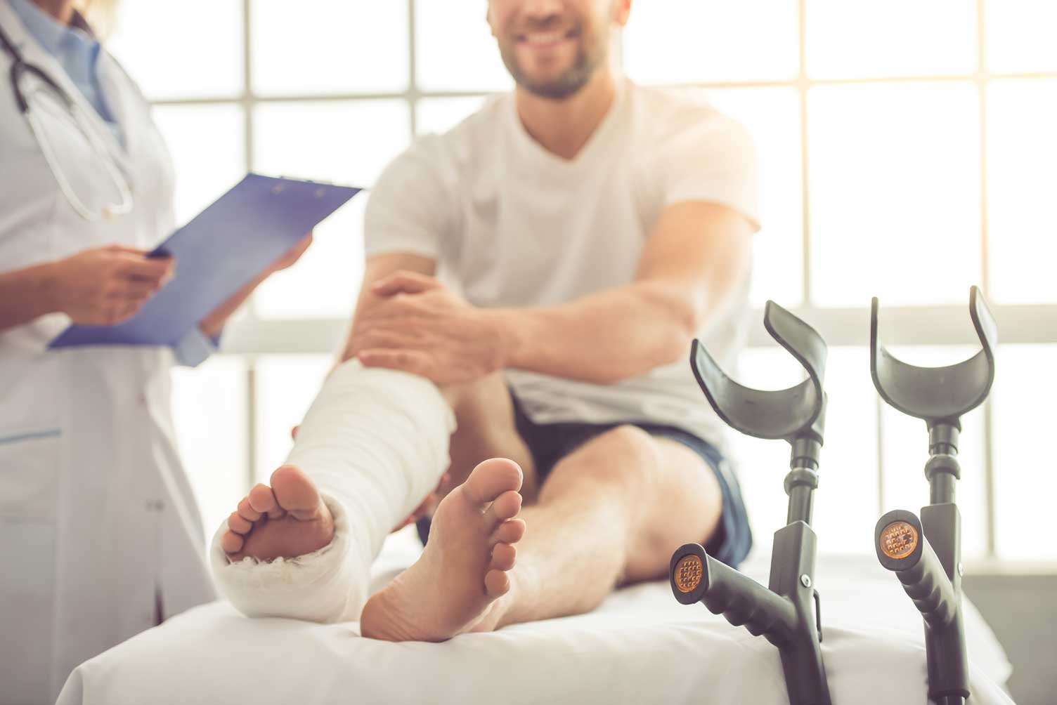 Utente com a perna imobilizada em gesso, acompanhado na consulta de Ortopedia