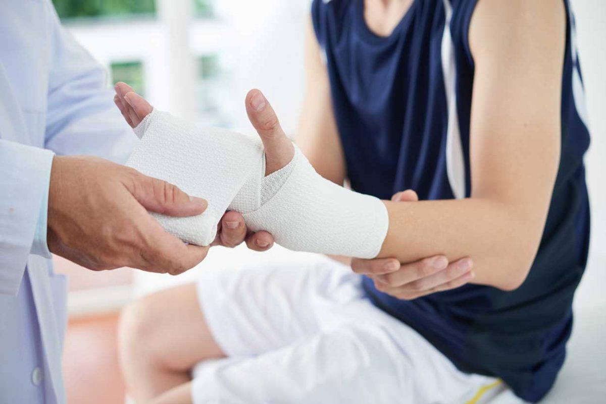 Ortopedia: imobilização do punho de um jovem atleta, verificada pelo médico